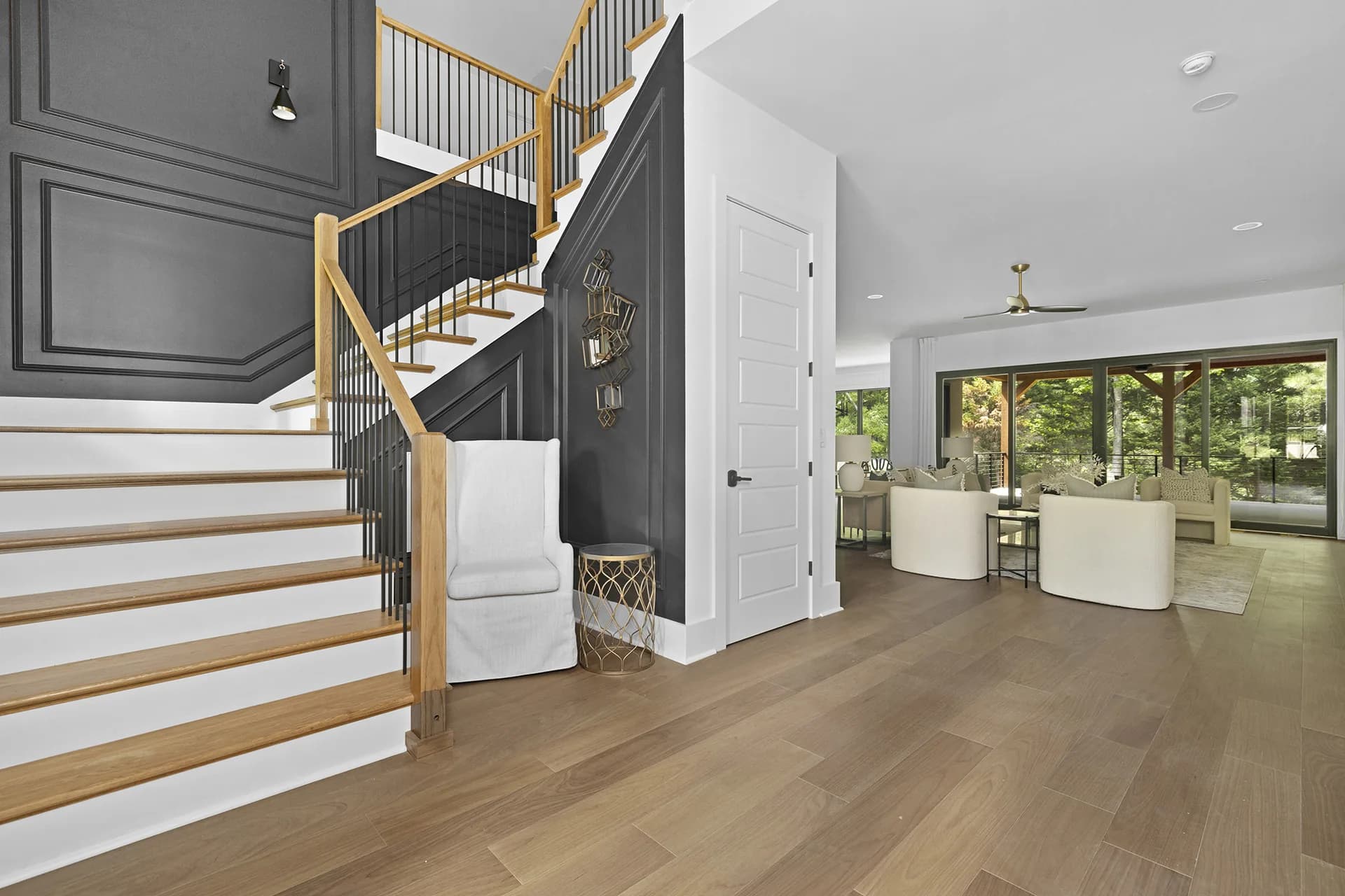 Wood staircase with dark metal railings and large windows in an RF home